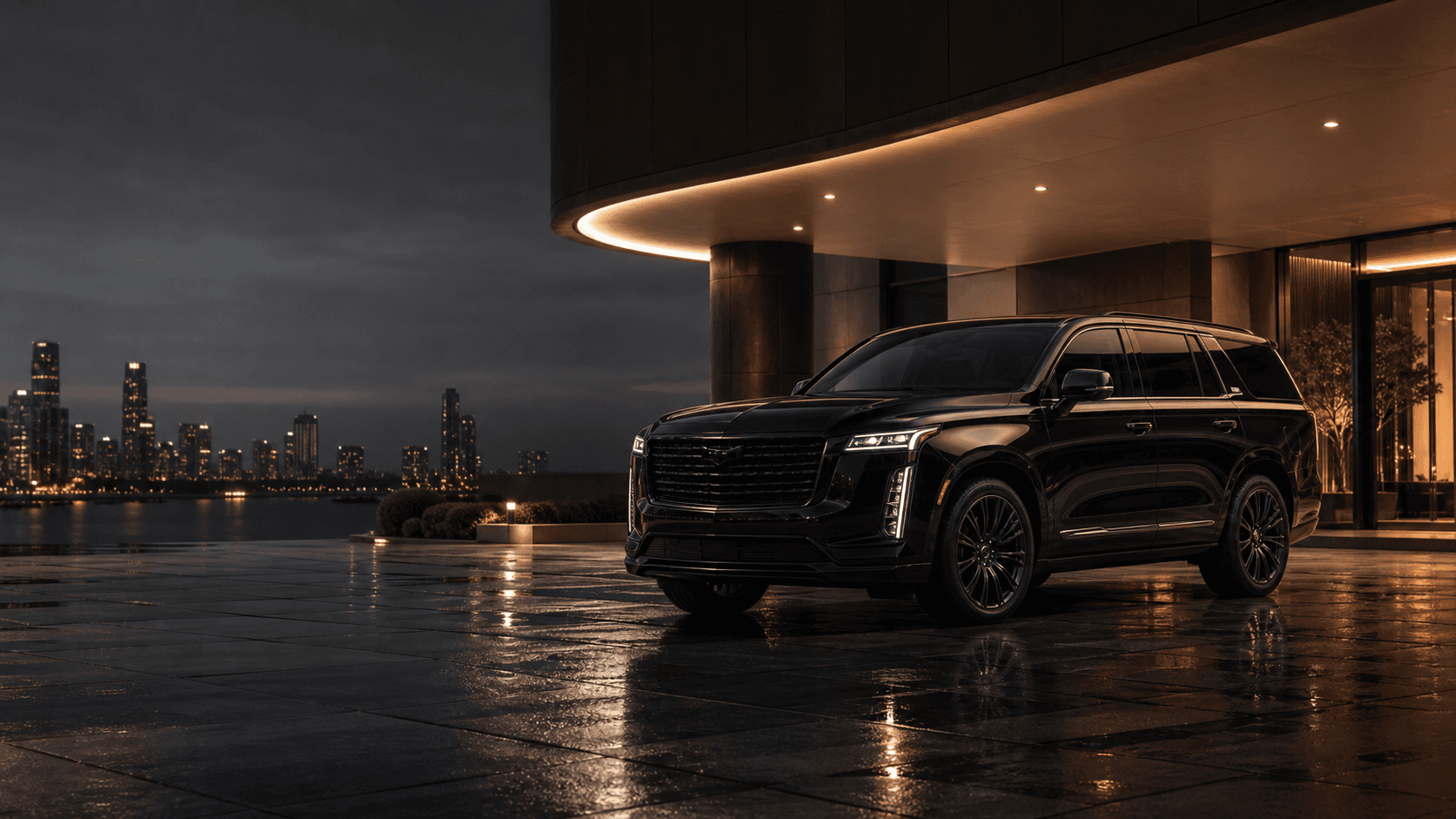 Black luxury SUV arriving at a premium hotel entrance at night
